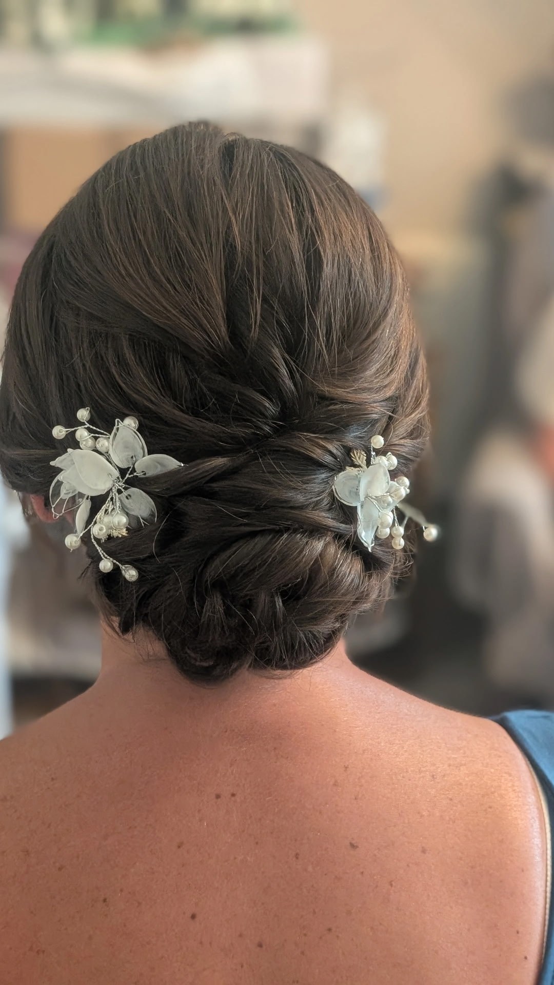 Soft brunette bridal chignon finished with white floral pins