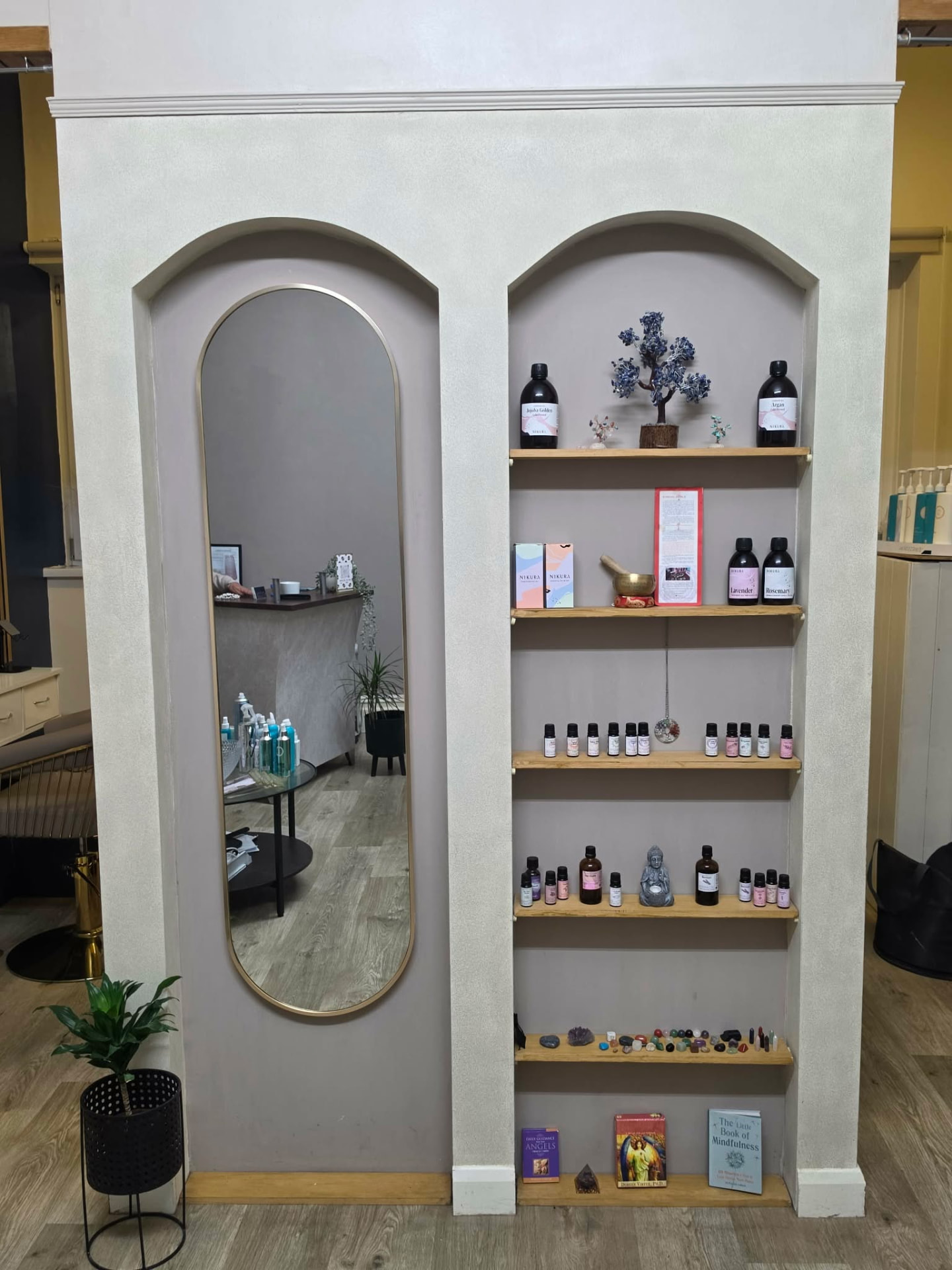Arched mirror and natural wellbeing shelves inside the salon at Mortimer Hair House