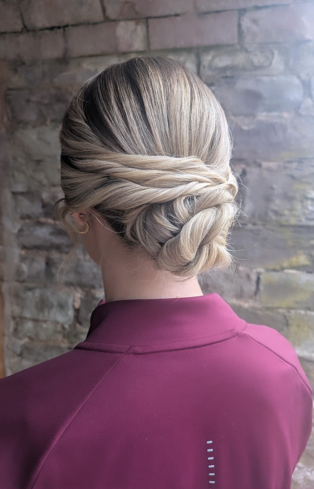 Twisted low chignon with soft face-framing pieces, styled by Hair Up Solutions